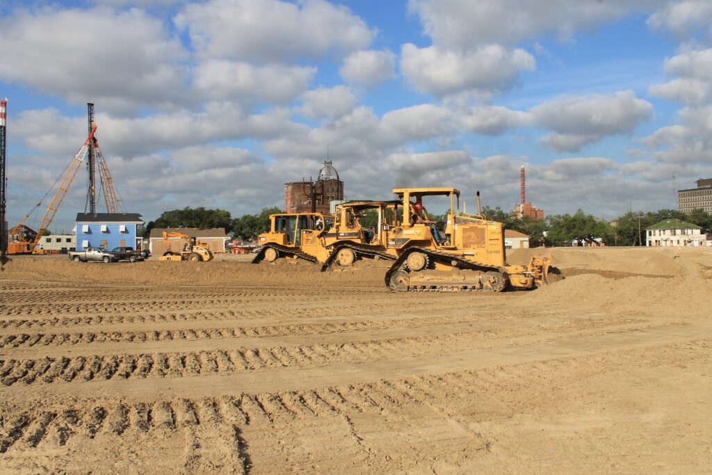 Three dozers leveling a construction site.