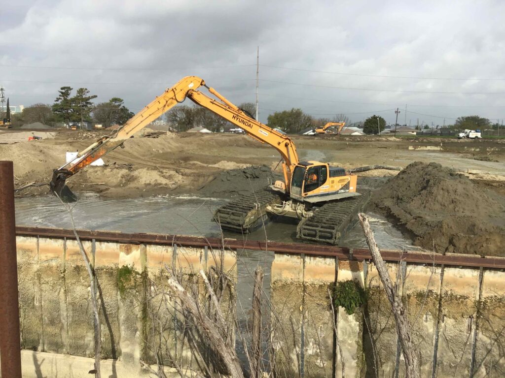 Heavy machinery called a marsh buggy at a demolition and site preparation site.
